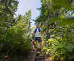 En kille i full färd med traillöpning i Orsa Grönklitts natursköna skogar - en energifylld löparupplevelse i naturen.