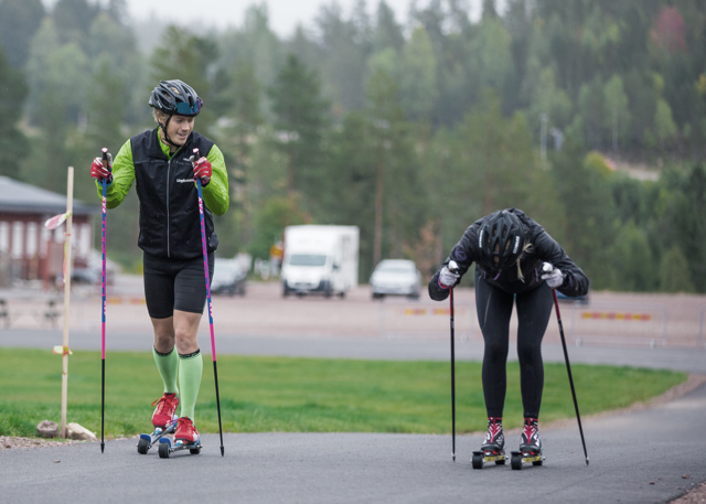 Instruktör visar rullskidteknik för nybörjare på plan väg
