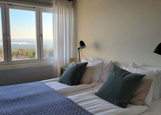 Bedroom with double bed, large windows, and view of Lake Orsa.