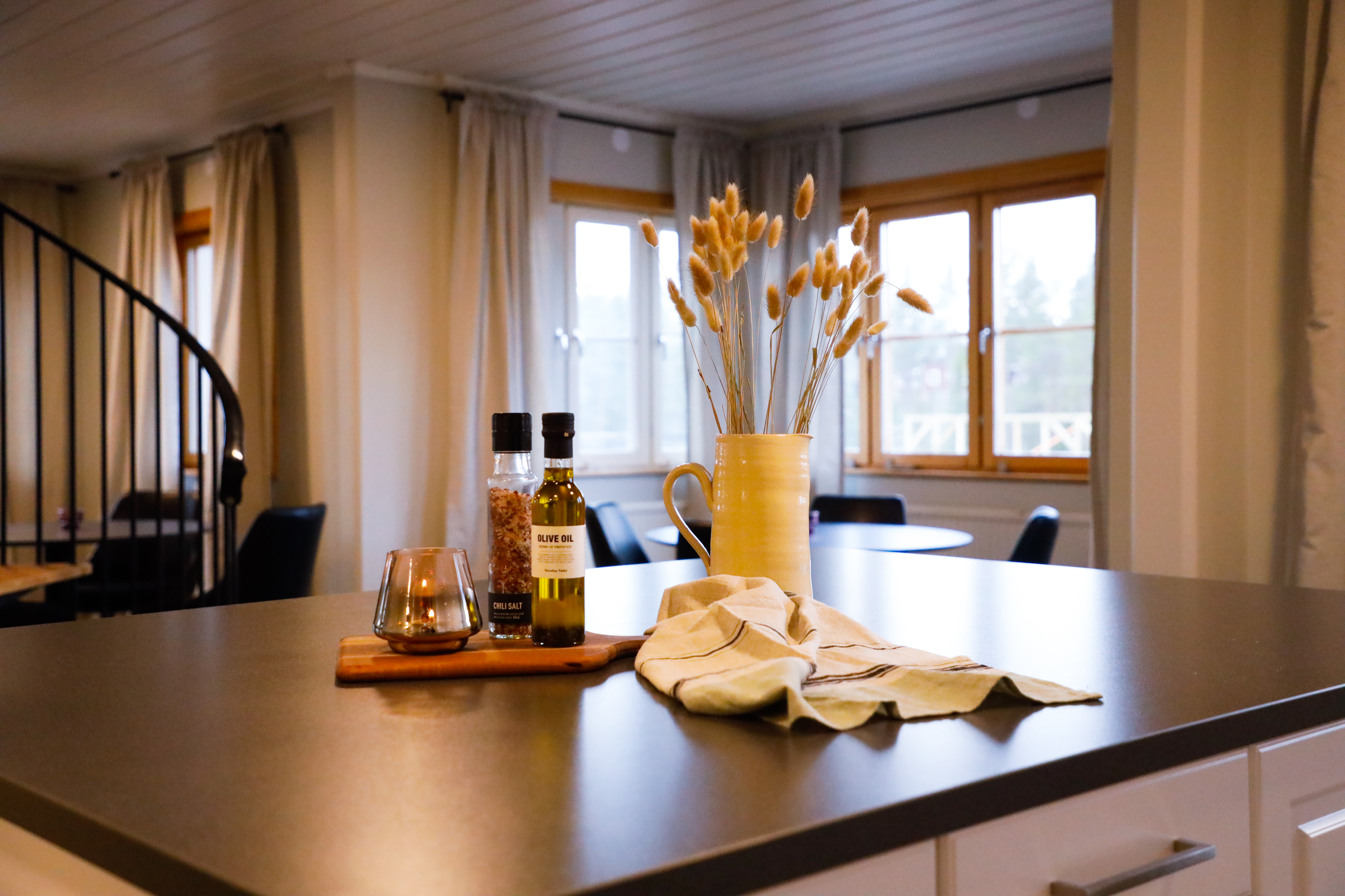 Köksö med olivolja, kryddor och torkade växter i ett modernt boende.