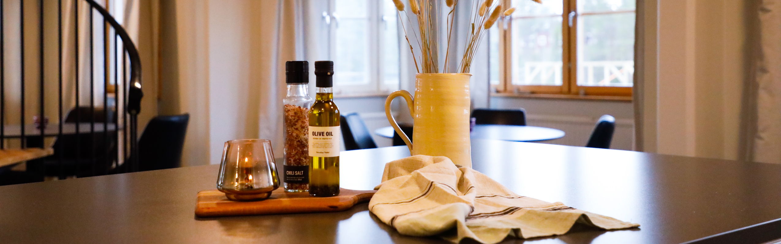 Kitchen island with olive oil, spices, and dried plants in a modern home.