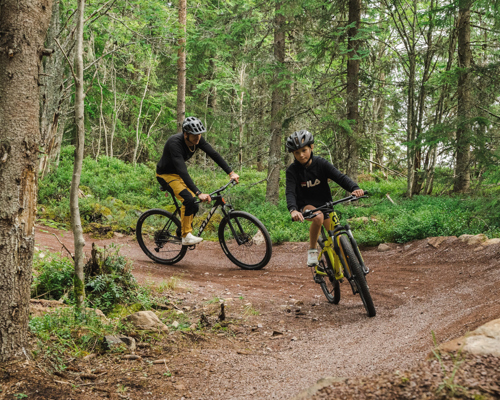 Två personer cyklar flowtrail i skog