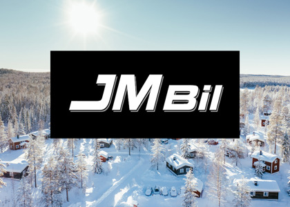 Logotyp för JM Bil centrerad över en solig vinterbild med snötäckta stugor och skog i bakgrunden.