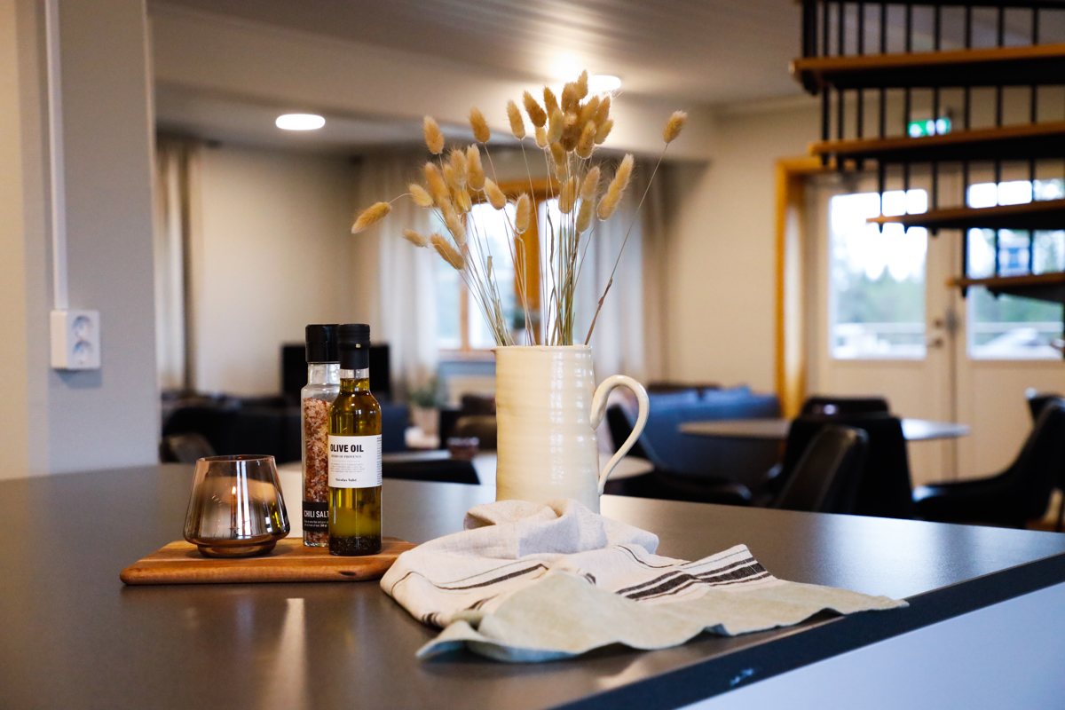 Köksö med kanna med torkade växter, kryddor och kökshandduk i gemensamt utrymme.