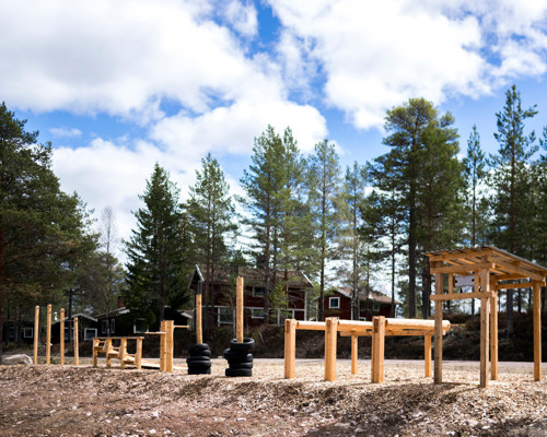 Outdoor gym in a forest setting with wooden ramps and workout equipment.