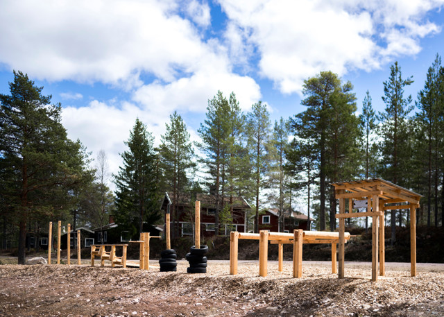 Utegym i skogsmiljö med träramper och träningsredskap.