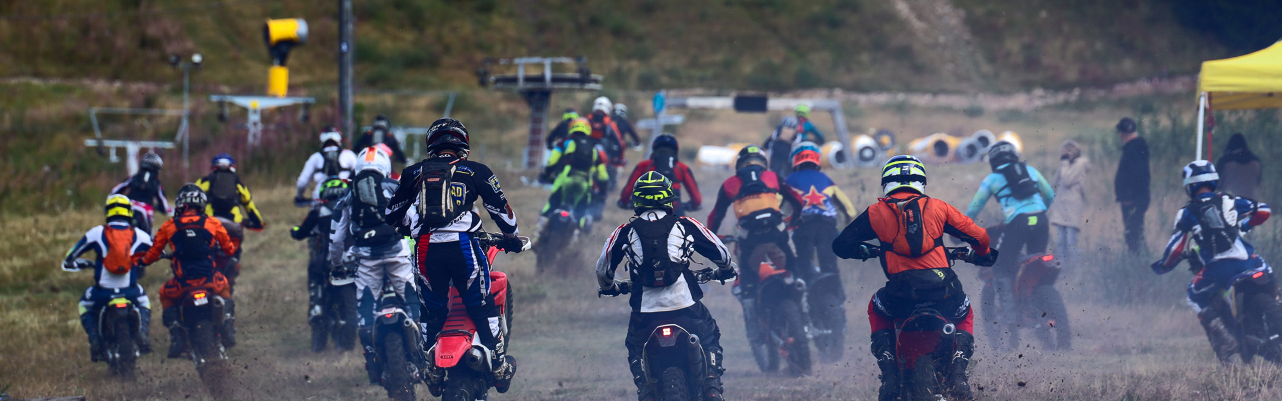 Flera personer kör motocross på en gräsbana och startar samtidigt.