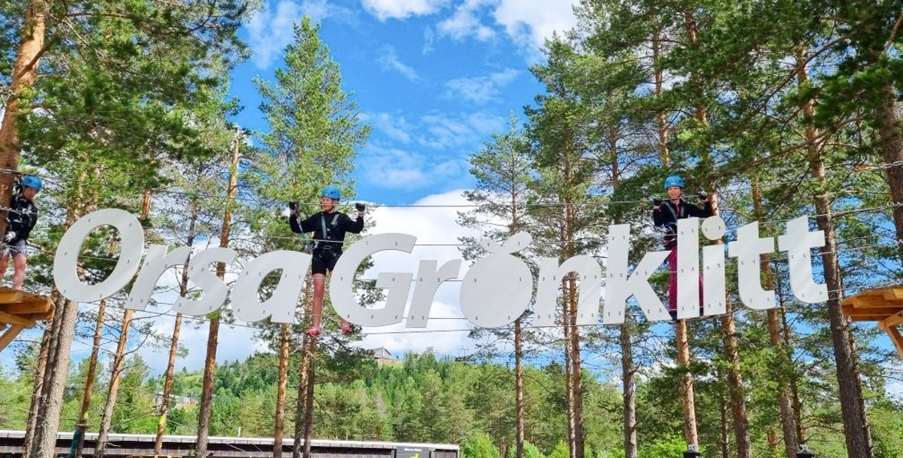 Två tjejer som går över hinder vid ingången till Grönklitts Klätterpark