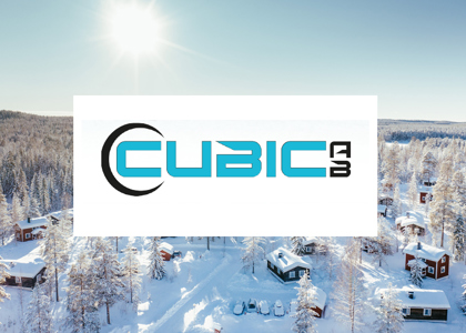 Logotyp för Cubic AB centrerad över en solig vinterbild med snötäckta stugor och skog i bakgrunden.