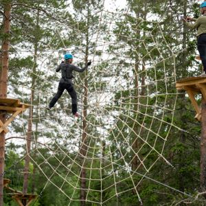 Unga killar klättrar i spindelnätet i Klätterparken, Orsa Grönklitt