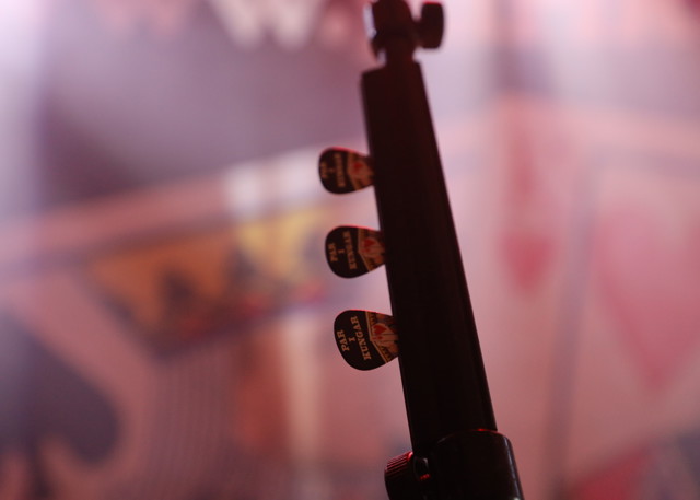 Närbild på gitarrens stämskruvar i motljus med oskarp logotyp i bakgrunden.